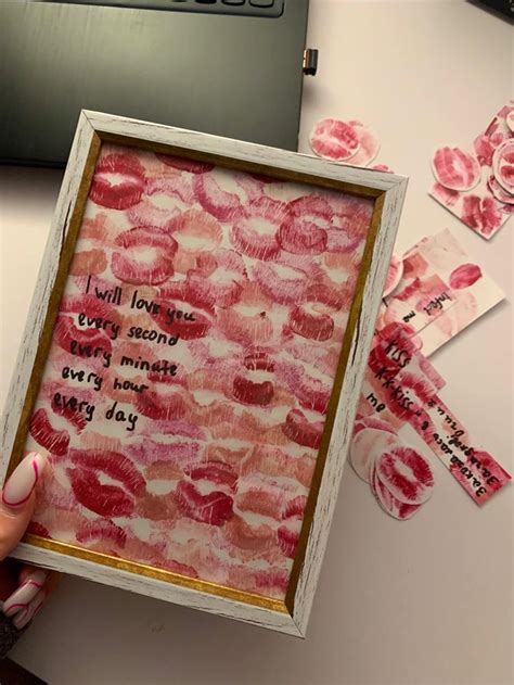 A Person Holding Up A Framed Piece Of Paper With Words Written On It And Pink Flowers In The