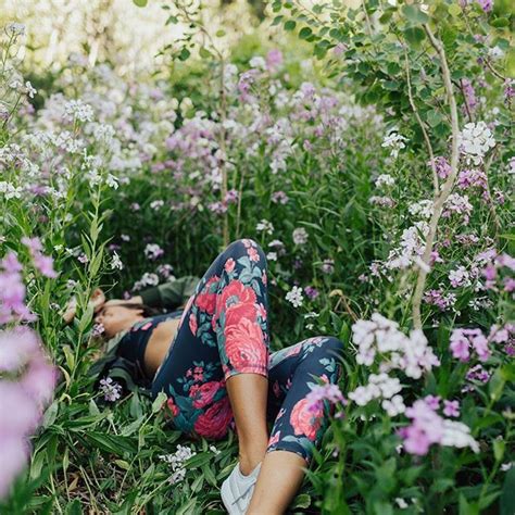 A Woman Laying On The Ground Surrounded By Flowers