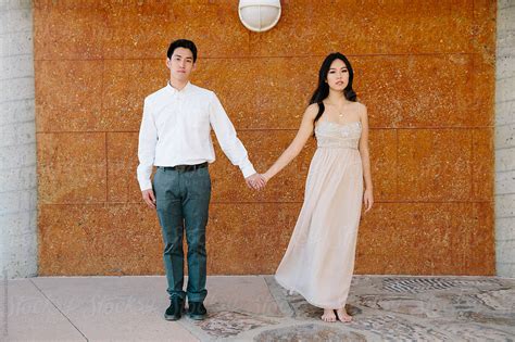 Young Asian Couple Standing And Holding Hands Del Colaborador De