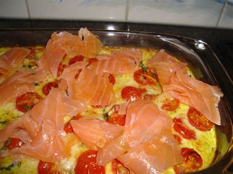 An Omelet With Salmon And Tomatoes In A Pan On Top Of The Stove