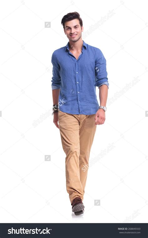 Young Happy Casual Man Walking Towards The Camera On White Studio