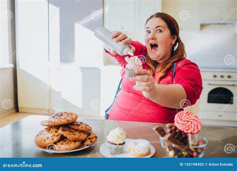 Fat Young Woman In Kitchen Sitting And Eating Sweet Food Excited Plus
