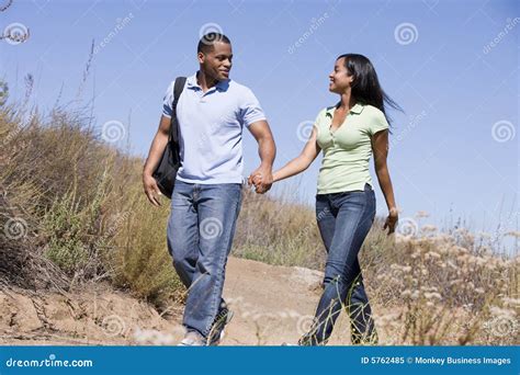 Couple Walking On Path Holding Hands And Smiling Royalty Free Stock