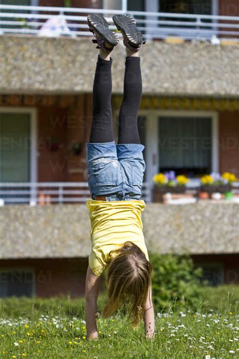 The fashion was dominated by festive, tropical brights, creamy pastels, and the nautical classics of red, white, and blue. Germany, Kiel, Girl doing handstand - JFE000030 - Jana ...