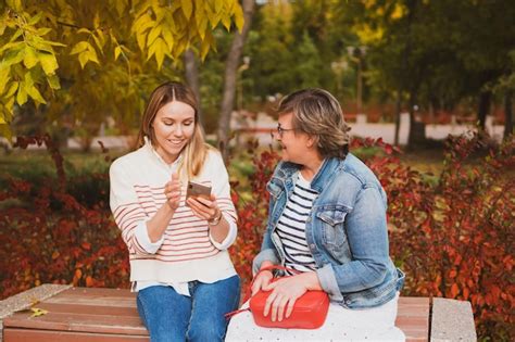 Premium Photo Charming Women Mom And Daughter Are Sitting On Bench In