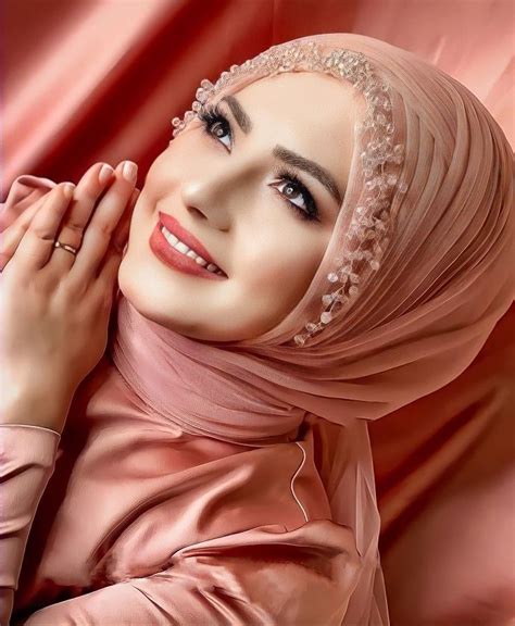 A Woman Wearing A Pink Hijab With Pearls On Her Head And Hands In Front