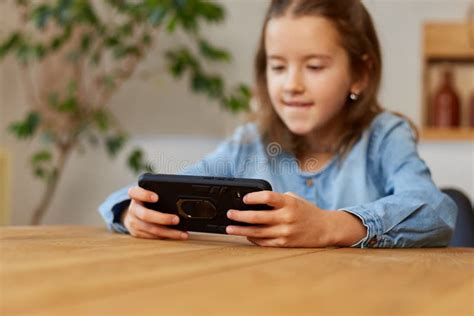 Happy Kid Girl Playing Game On Mobile Phone At Home Stock Image Image