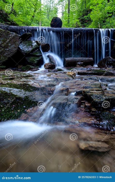 Long Exposure Shot Of A Small River Cascade Flowing Down Mossy Rocks