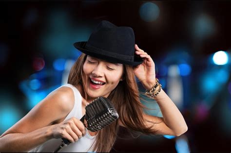 Premium Photo Young Woman Wearing Hat Singing Into Microphone