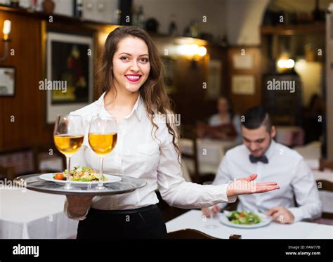 Smiling Russian Female Waiter Serving Guests Table In Restaurant Stock