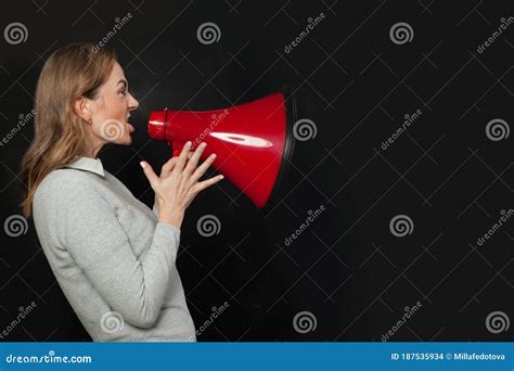 Angry Woman Shouting With Loudspeaker Megaphone On Black Background
