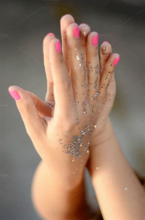 A Womans Hand With Pink And Silver Glitters On It Holding Her Hands