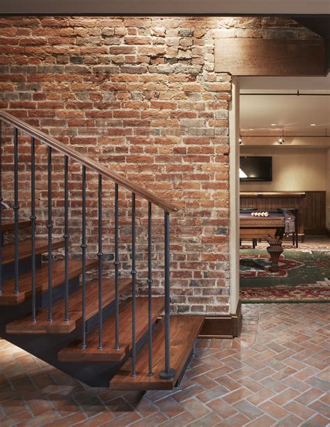 A Brick Wall With Stairs Leading Up To A Living Room And Kitchen Area