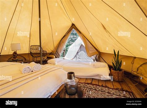 Luxurious interior of spacious camping tent with cozy beds near carpet