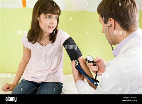 Doctor Checking Young Girl Blood Pressure Stock Photo Alamy
