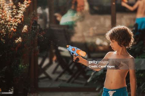 Little Boy Plays Water Gun Fight High Res Stock Photo Getty Images