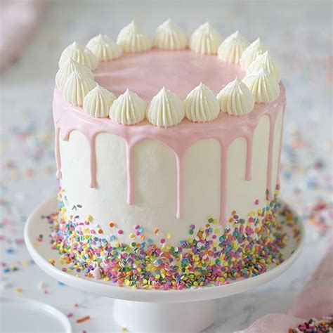 Photo Of A Pink And White Funfetti Cake Covered In Sprinkles Drip
