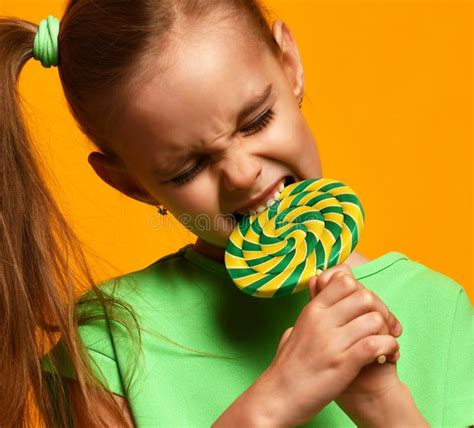 Happy Young Little Child Girl Kid Bite Sweet Lollypop Candy Stock Photo