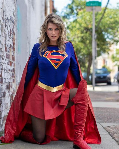 A Woman In A Superman Costume Poses On The Sidewalk