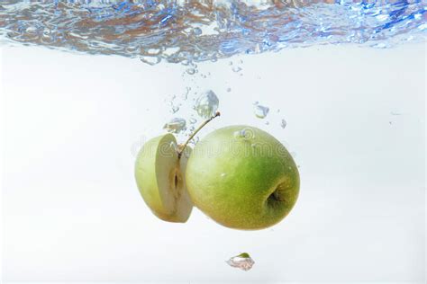 Green Apple Under Water With A Trail Of Transparent Bubbles Stock Image