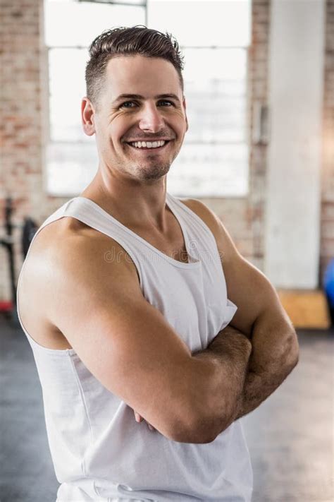 Portrait Of A Muscular Man Smiling With Arms Crossed Stock Photo