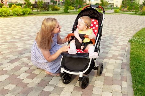 Premium Photo A Young Mother Walks With A Baby In A Stroller In The