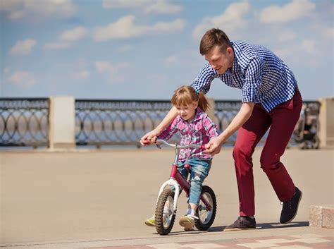 Padre Enseñando A Hija A Andar En Bicicleta Foto Premium