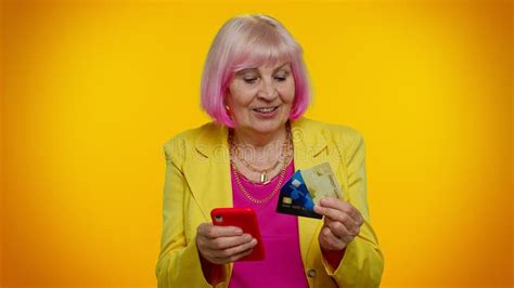 senior old granny woman using credit plastic cards and mobile phone purchases online shopping