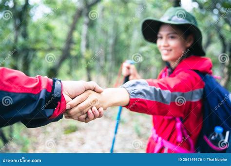 Person Hike Friends Helping Each Other Up A Mountain Man And Woman