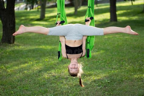 Little Girl Doing Yoga Exercises With A Hammock In The Park Stock