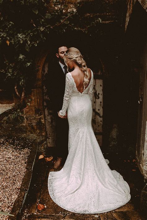 elegant white wedding in somerset with bride in lace long sleeved gown with open back and loose
