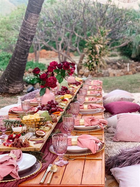 A Long Table Set Up With Plates And Place Settings For An Outdoor Dinner In The Woods