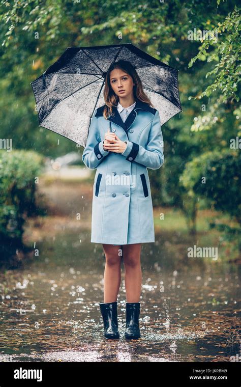 Portrait Of Teenage Girl Holding Umbrella While Standing On Pathway