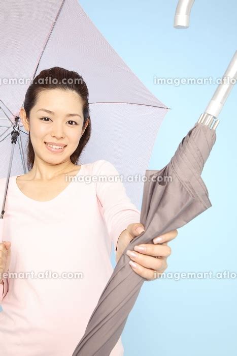 傘を渡す女性 23989860 イメージマート