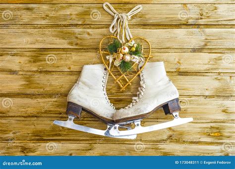 Vintage Ice Skates For Figure Skating With Fir Tree Branch Hanging On Rustic Background