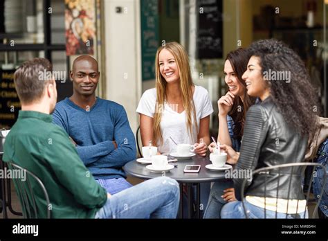 Multiracial Group Of Five Friends Having A Coffee Together Three Women