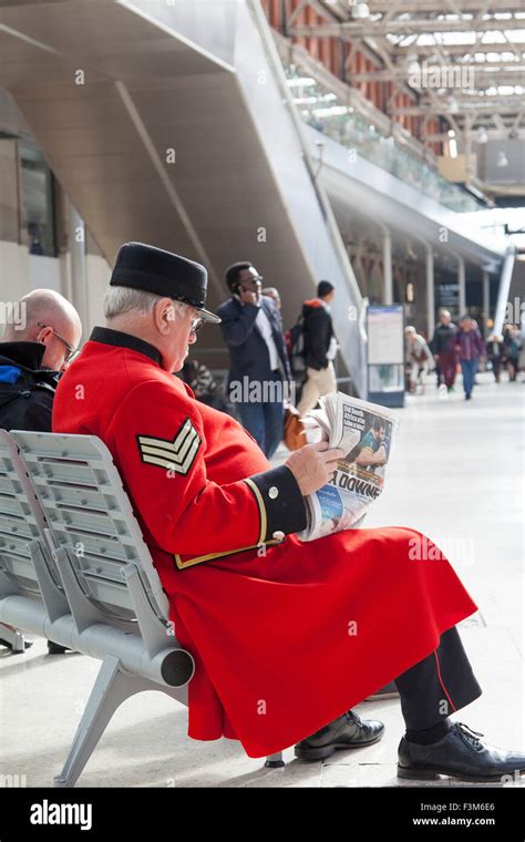 a chelsea pensioner at waterloo station london wearing his long red coat with military rank
