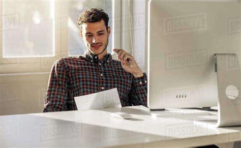 Man Sitting At His Desk In Office Looking At A Business Paper Entrepreneur Reading A Paper