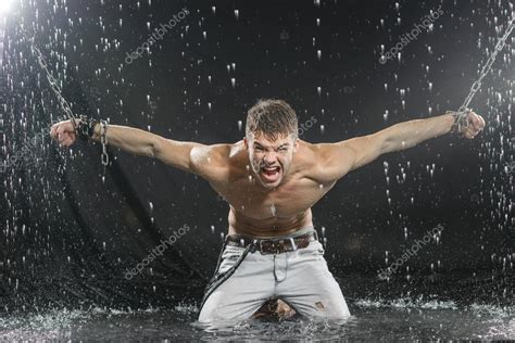 Starker Mann In Ketten Unter Dem Regen Aqua Studio Posieren Stockfoto