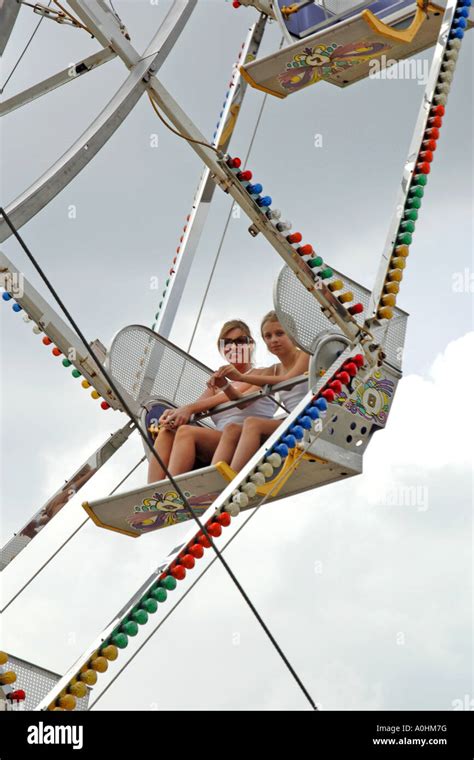 Two Teenage Females Having Fun On The Ferris Wheel At The Fairground