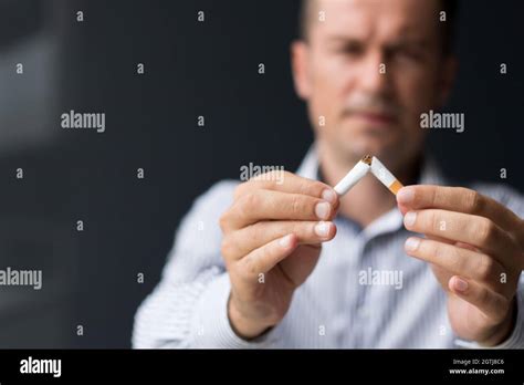 Close Up Of Man Breaking Cigarette In Half Quitting Smoking Habit