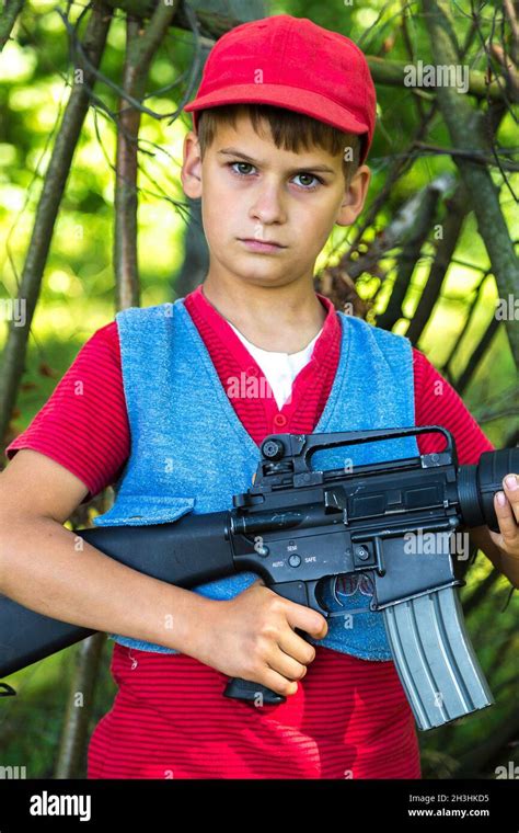 Boy Holding A Gun In The Field Stock Photo Alamy