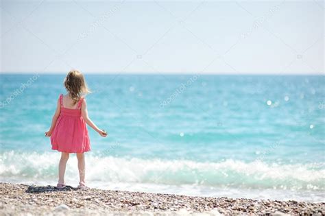 Niña en una playa de guijarros fotografía de stock MNStudio