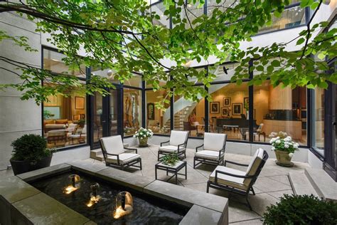 An Outdoor Living Area With Chairs Tables And Water Feature In The