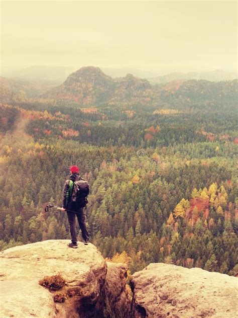 Tall Hiker Man With Red Cap Poles In Hand And With Big Backpack Stand On Rock Misty Spring