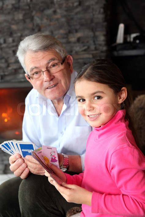old man playing card game with his granddaughter stock image colourbox