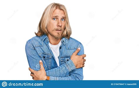 Caucasian Man With Blond Long Hair Wearing Casual Denim Jacket Shaking