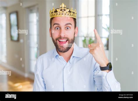 Handsome Business Man Wearing Golden Crown As A King Or Prince Pointing