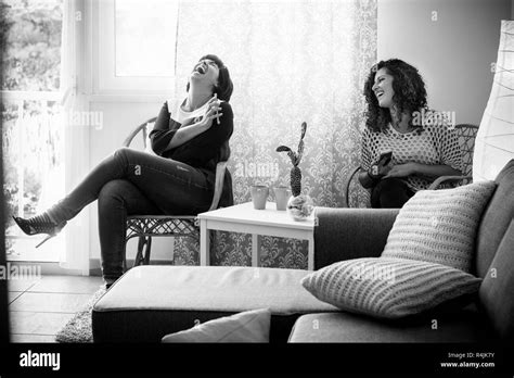 Black And White Image With Couple Of Young Women Friends At Home Laughing And Having Fun