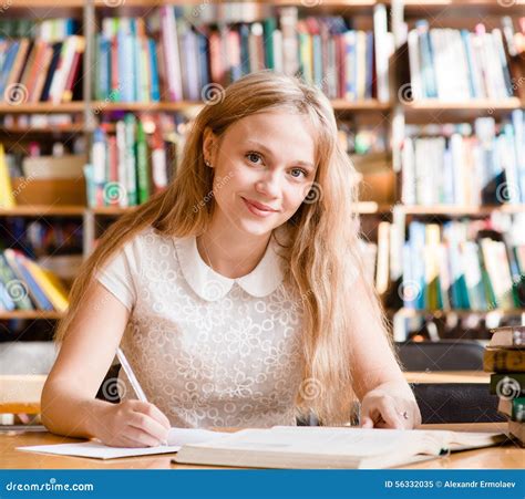 Portrait Of A Pretty Female Student Studying In Library With Open Book